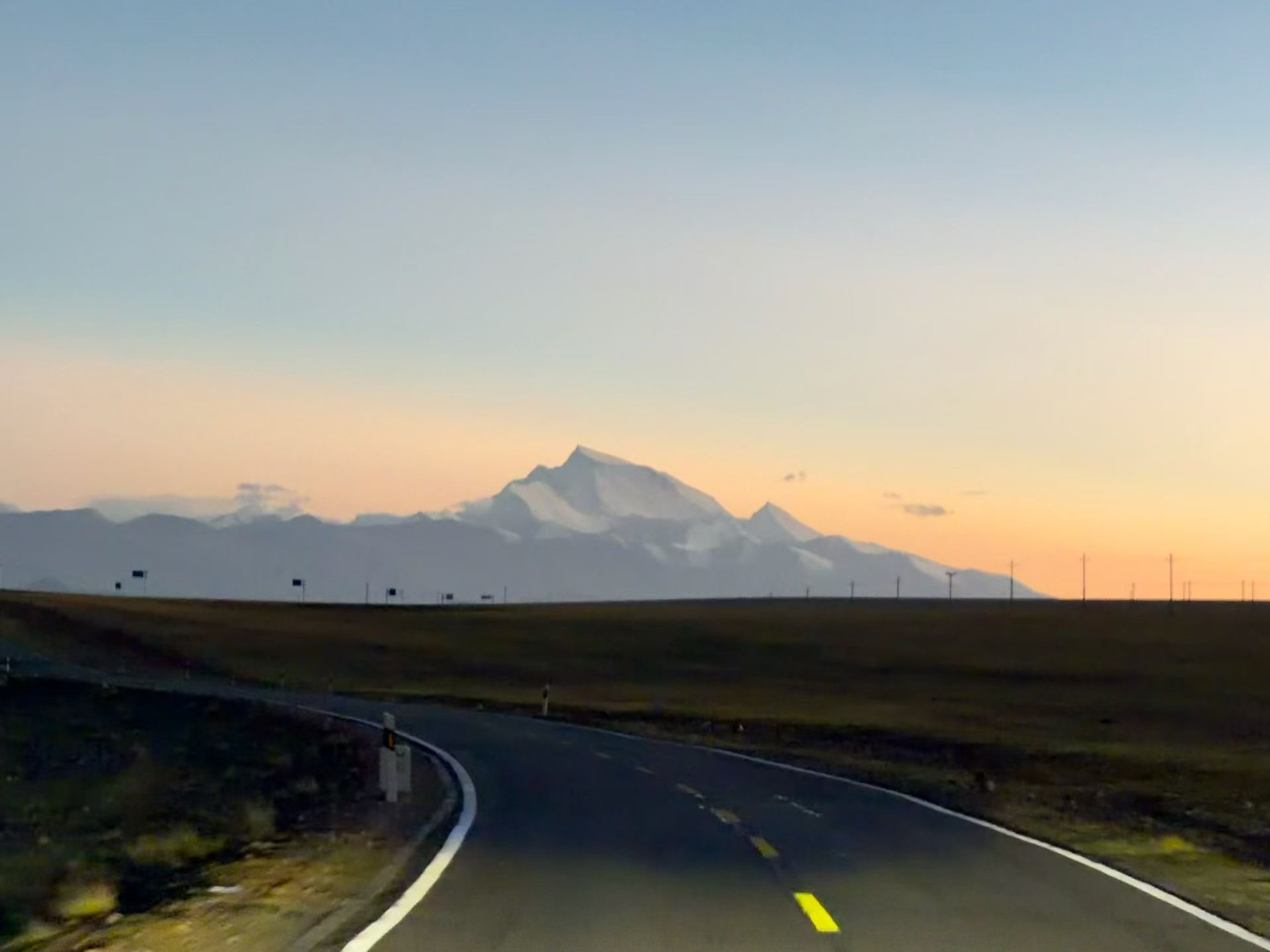 A road leading toward the mountains of Tibet at sunrise